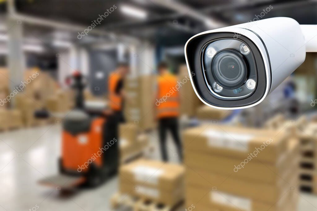 Technician configuring CCTV camera in warehouse